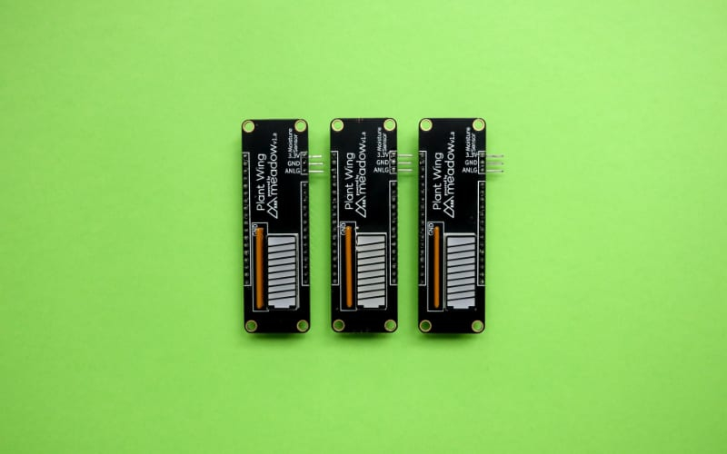 three small electronic components displayed on a vibrant green background