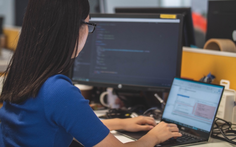 a woman focused on her computer while working in a modern office environment
