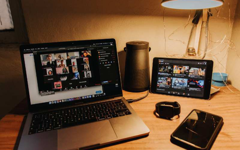 a loptop, tablet, phone and a smart watch on top of a desktop