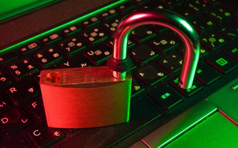 an opened padlock resting on a laptop keyboard, symbolizing digital security and data protection