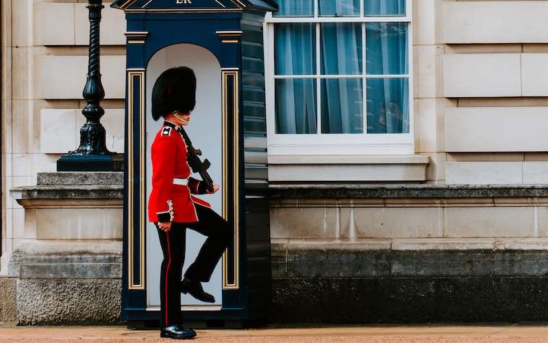 a british royal guard wearing a red uniform, indicating a formal or ceremonial context