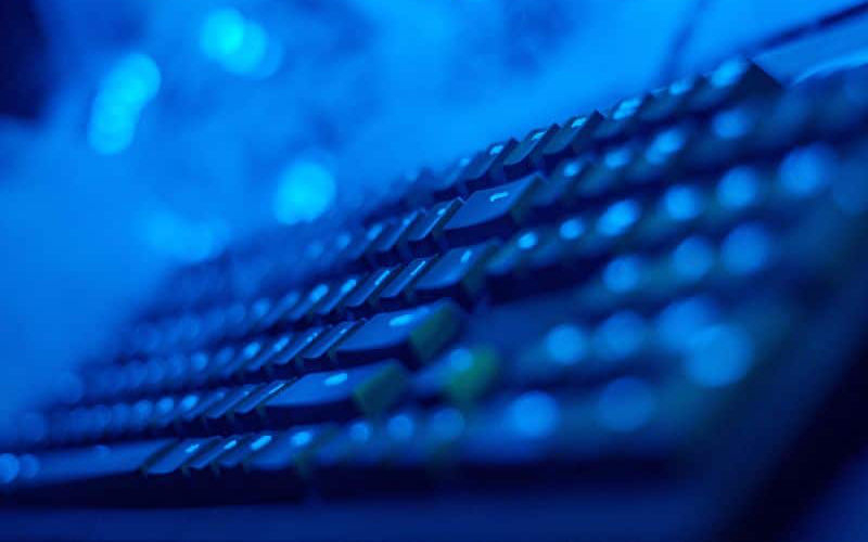 a close-up view of a keyboard illuminated in blue lighting