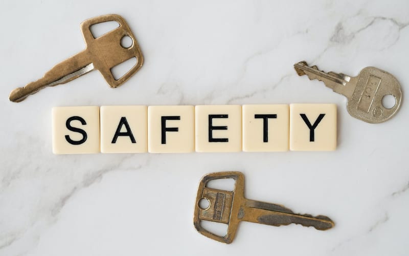 keys beside scramble blocks spelling out the word "safety" on top of a white table