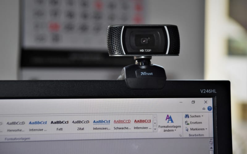 a closeup view of an hd 720 trust web camera being mounted on top of a v246hl computer monitor