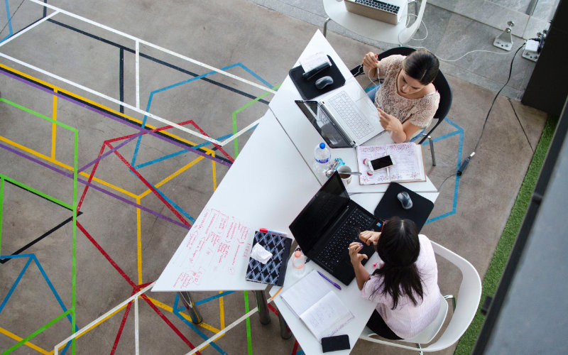 Work together to identify the outcomes top view of two women working together using their laptops inside a working station